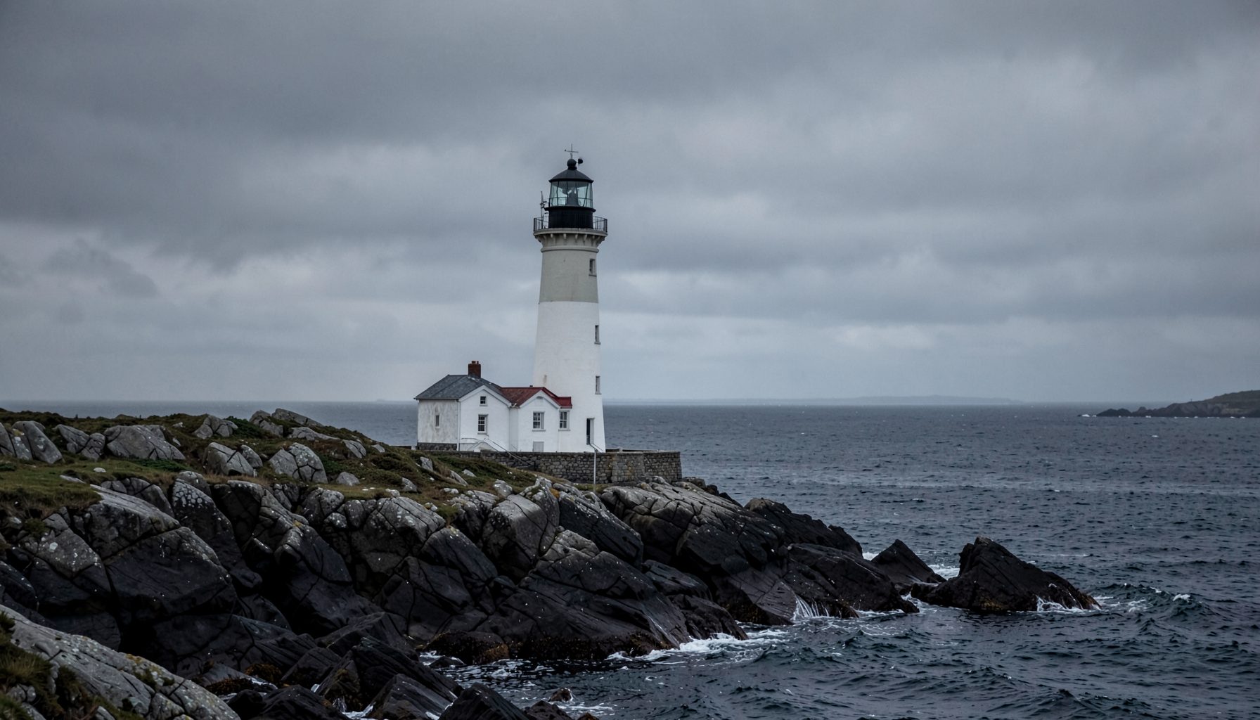 Lonely lighthouse on a rocky northern coastline, grey sky and dark sea, stark and atmospheric
